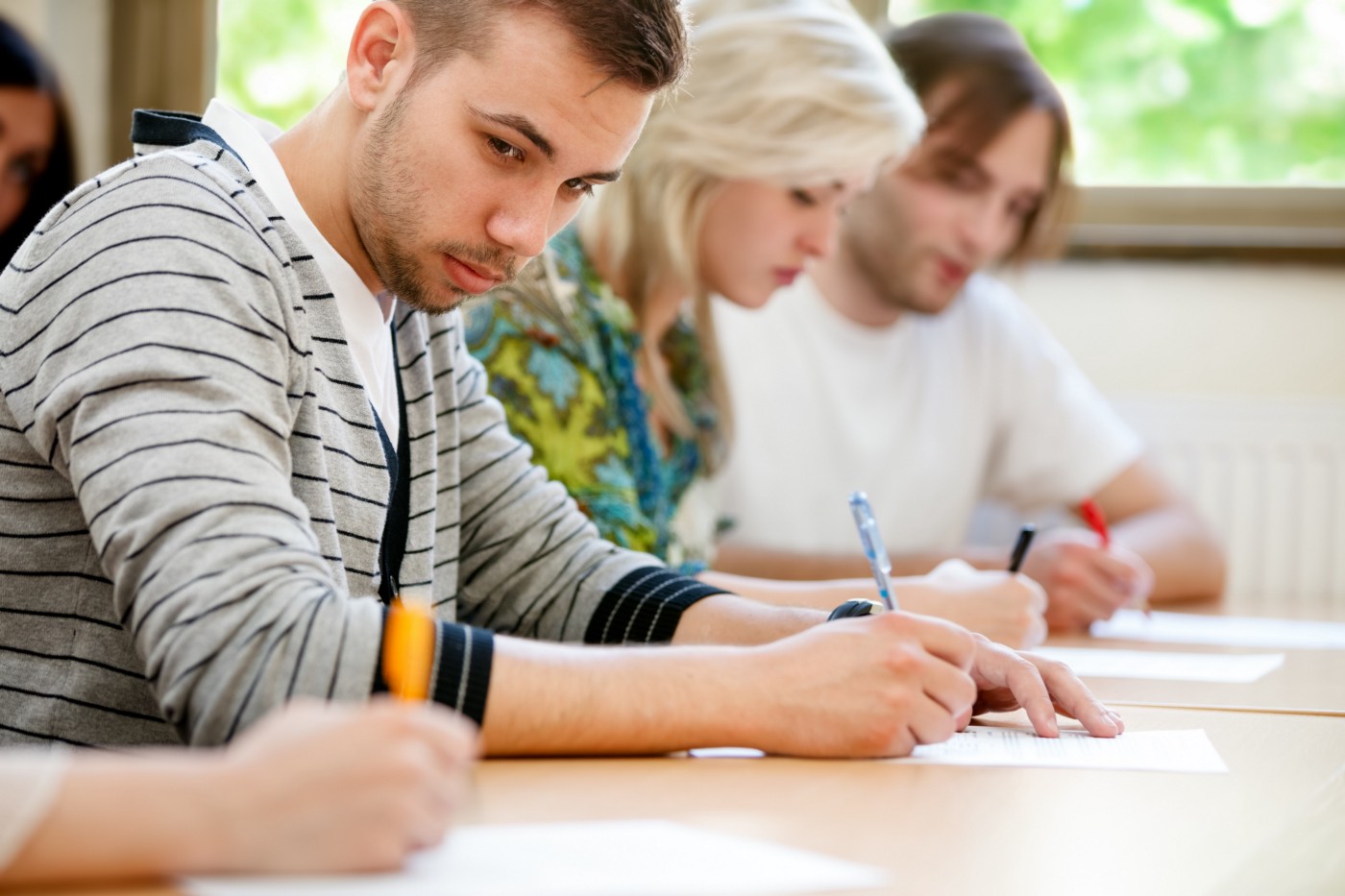 A student taking a test and turning his head to look at his neighbor's paper, presumably to copy the answers.